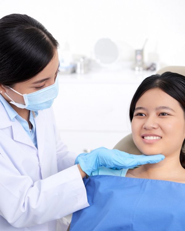 After teeth whitening Vietnamese girl smiling after having her teeth treated